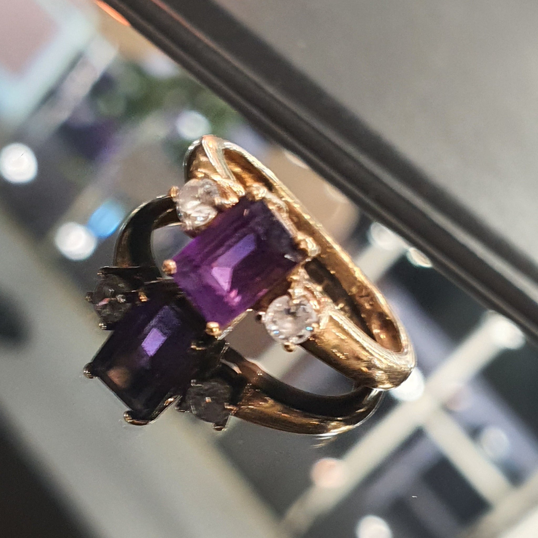 Emerald-cut amethyst rings in rose gold, photographed in the cabinet at Little Shambles Jewellers, 42 Shambles York
