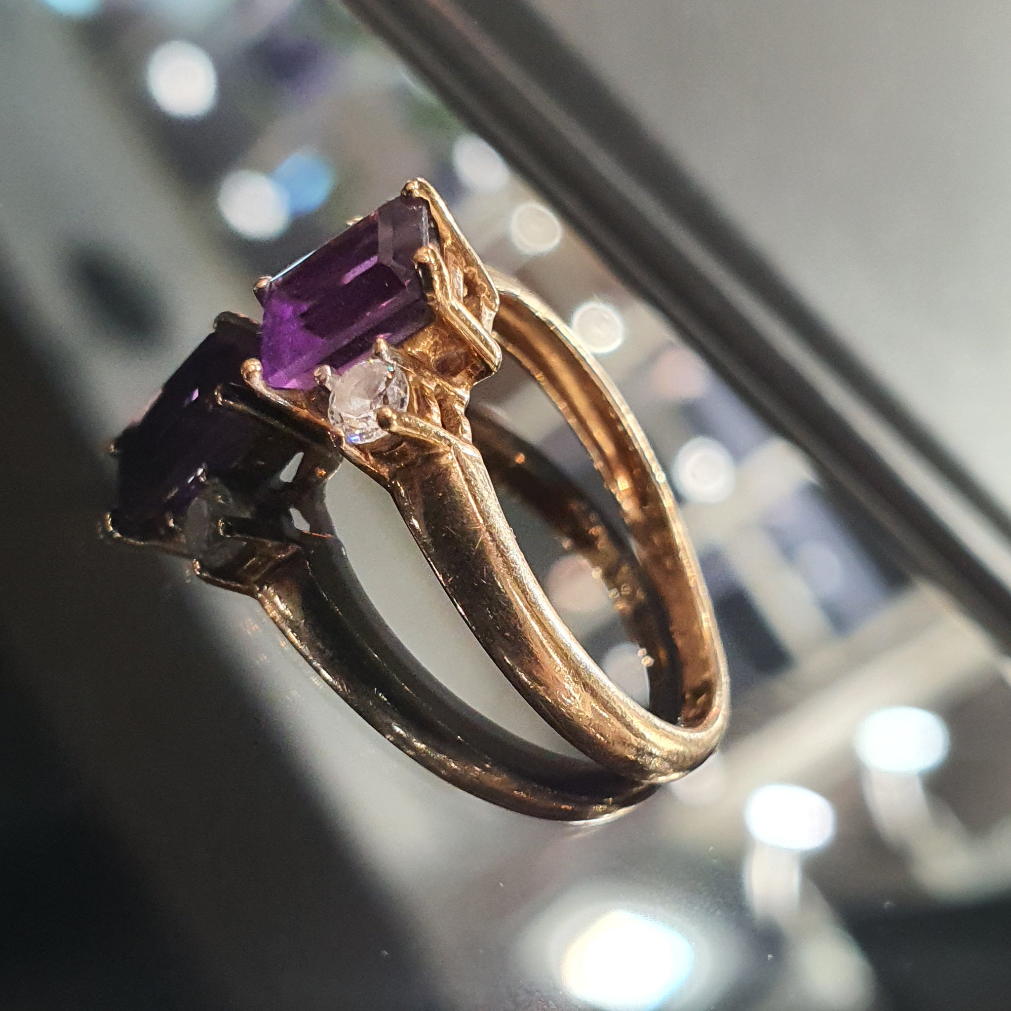 An emerald-cut amethyst and rose-gold ring from Little Shambles Jewellers, photographed in the shop cabinet